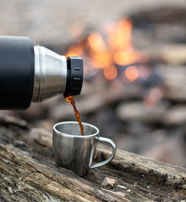 silver and black coffee mug on brown wooden table